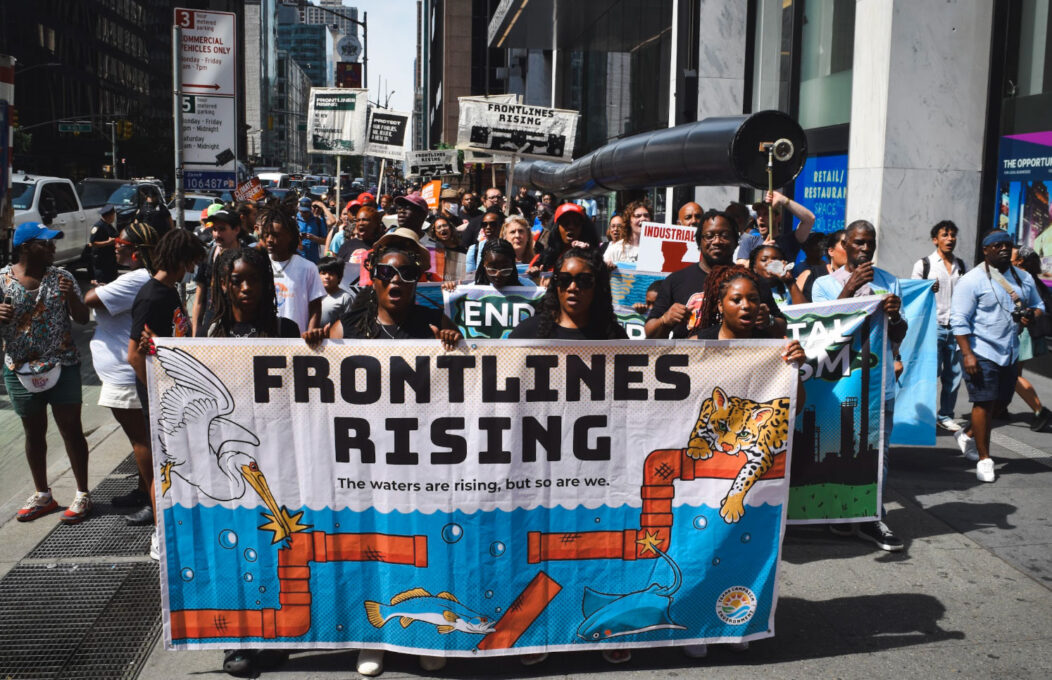 Activists from the Vessel project at the Summer of Heat protest carry banners through the streets.